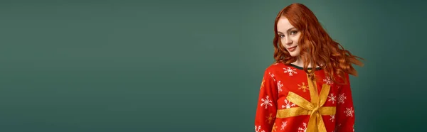Jeune rousse femme sourit tout en posant dans un pull de Noël, célébrer les vacances d'hiver, bannière — Photo de stock
