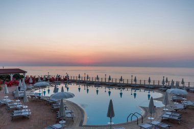 Lüks bir tatil köyünde gün batımında güzel bir yüzme havuzu, Calabria, İtalya 'da popüler bir turizm merkezi olarak Trope..