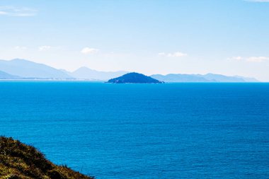 High view of Campeche Island in Florianopolis Brazil from the trail from Matadeiro to Lagoinha do Leste at Florianpolis, Brazil. A beautiful blue tone sea. clipart