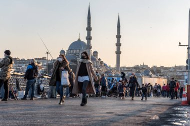 Coronavirus COVID-19 salgını sırasında Galata Köprüsü 'nde yürüyen koruyucu maskeler takan kimliği belirsiz Türk vatandaşları. İstanbul, Türkiye. 16 Kasım 2020