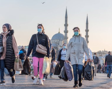 Coronavirus COVID-19 salgını sırasında Galata Köprüsü 'nde yürüyen koruyucu maskeler takan kimliği belirsiz Türk vatandaşları. İstanbul, Türkiye. 16 Kasım 2020