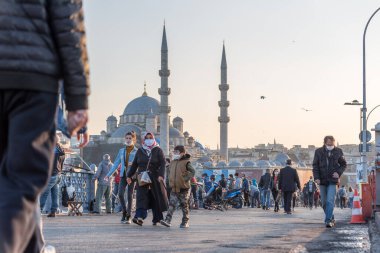 Coronavirus COVID-19 salgını sırasında Galata Köprüsü 'nde yürüyen koruyucu maskeler takan kimliği belirsiz Türk vatandaşları. İstanbul, Türkiye. 16 Kasım 2020