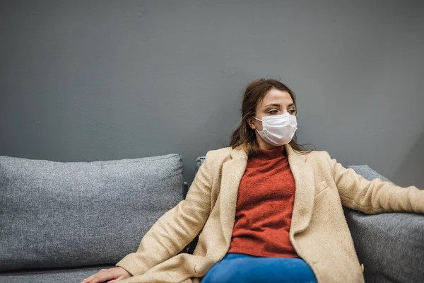 Hermosa Mujer Con Máscara Médica Protectora Ropa Moda Descansa Silla Fotos de stock libres de derechos