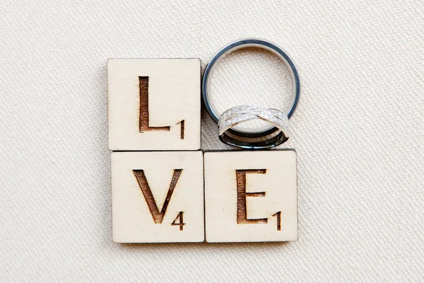 Anéis de casamento em letras Scrabble LOVE — Fotografia de Stock