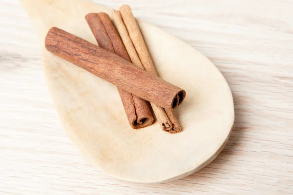 Palitos de canela en una cuchara de madera —  Fotos de Stock