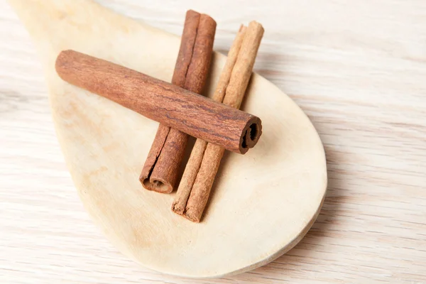 Palitos de canela en una cuchara de madera —  Fotos de Stock