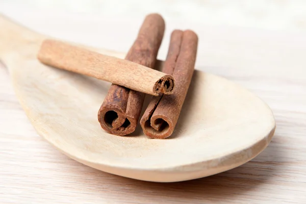 Bâtonnets de cannelle sur une cuillère en bois — Photo