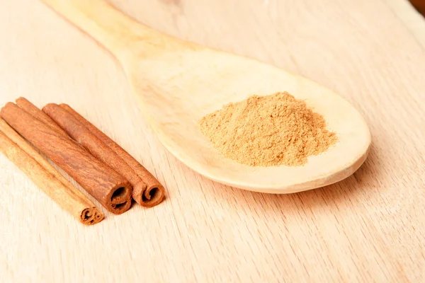 Laski cynamonu i cynamon w proszku na drewnianą łyżką — Zdjęcie stockowe