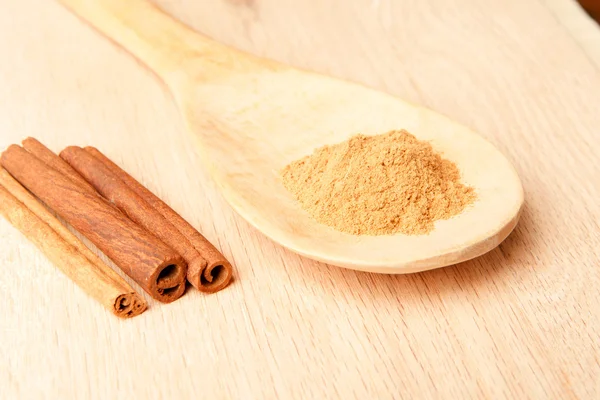 Cinnamon sticks and cinnamon powder on a wooden spoon — Stock Photo, Image