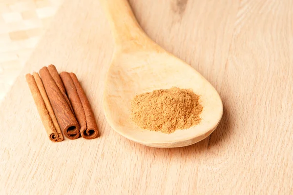 Cinnamon sticks and cinnamon powder on a wooden spoon — Stock Photo, Image