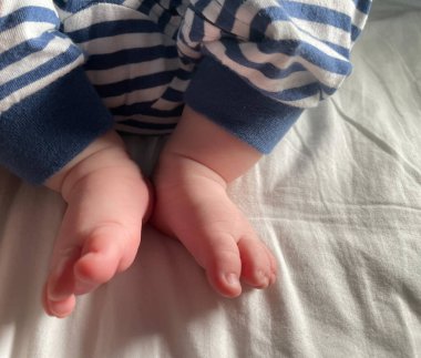 Küçük çocuk, küçük ayaklar, çoraplar yok, küçük parmaklar, yatakta oynamak, mavi