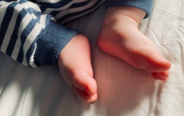 Küçük çocuk, küçük ayaklar, çoraplar yok, küçük parmaklar, yatakta oynamak, mavi