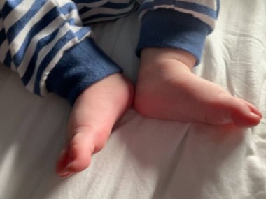 Küçük çocuk, küçük ayaklar, çoraplar yok, küçük parmaklar, yatakta oynamak, mavi