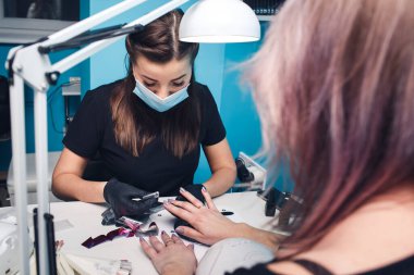 Manikür işlemi. Usta bir güzellik salonunda manikür yapıyor..