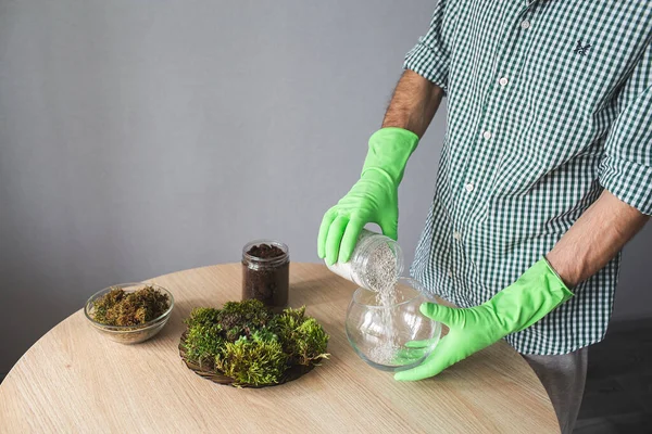 Primo piano di mani guantate versando perlite in un vaso. preparazione per il trapianto di piante da interno. — Foto Stock
