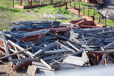 Açık bir alanda çelik bina yapıları depolanmış.