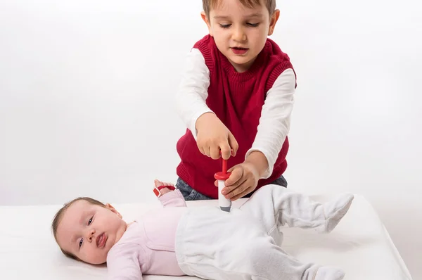 Brother and sister playing doctor and patient — Stock Photo, Image