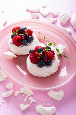 Pavlova kremalı pasta ve toz şekerli pembe arka plan.