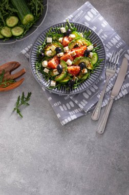 Taze vejetaryen roket salatası, salatalık, domates, peynir, avokado ve balzamik jöleli zeytin ve gri taşın üzerine susam tohumları.