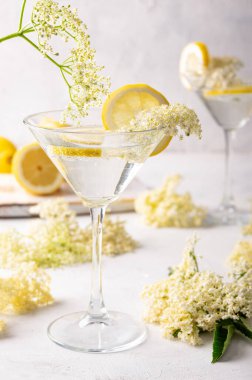 Yaşlı çiçekli cin tonik limonlarla süslenmiş ferahlatıcı yaz kokteyli.