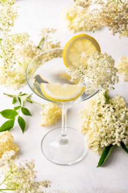 Yaşlı çiçekli cin tonik limonlarla süslenmiş ferahlatıcı yaz kokteyli.