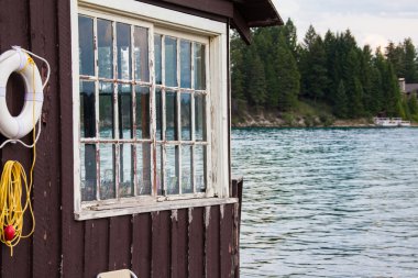 Montana bozulmamış Kaya Dağları'nda bir göl üzerinde eski bina.