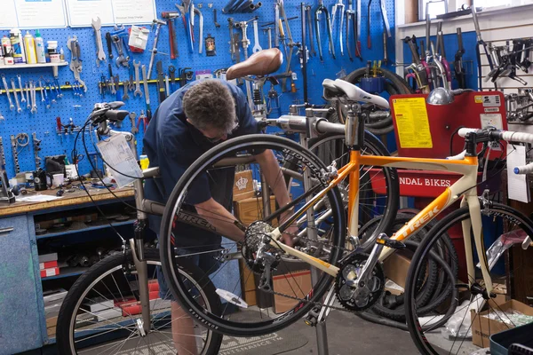 Человек Ремонтирует Велосипед Магазине Велосипедов — стоковое фото