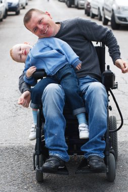 Tekerlekli sandalye üzerinde oğluyla Engelli adam