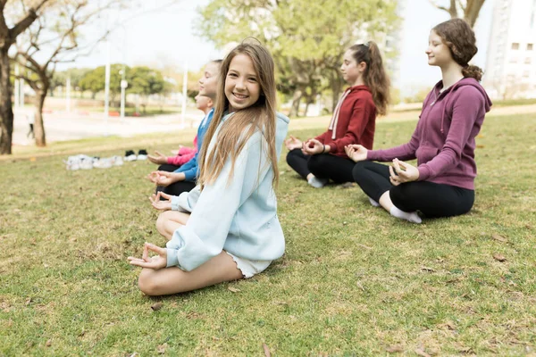 一群女孩在外面练瑜伽 图库照片