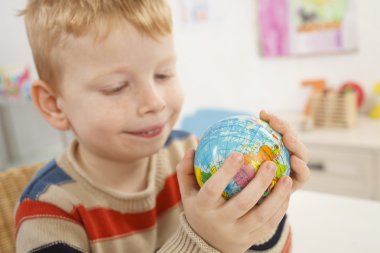 Preschooler with globe in a hand