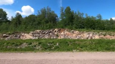 Güneşli bir yaz gününde hareket halindeki araçtan ormana, mavi gökyüzüne ve bulutlara bakın. Böyle bir havada, araba penceresi açıkken bile sürebilirsin..