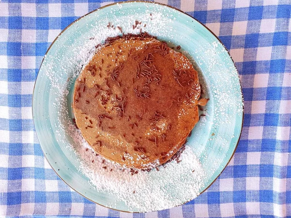 Mavi tabakta çikolatalı gözleme. Gözlemeler çikolata parçacıkları ve pudra şekeri serpiştirilmiş..