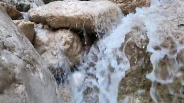 Nehrin kaynağında nehir suyu akıntısı. Su taşların arasından hızla akıyor. Kayalık dağların arasında güzel bir doğa yaratımı.