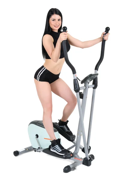 Young woman doing exercises on elliptical cross trainer — Stock Photo, Image