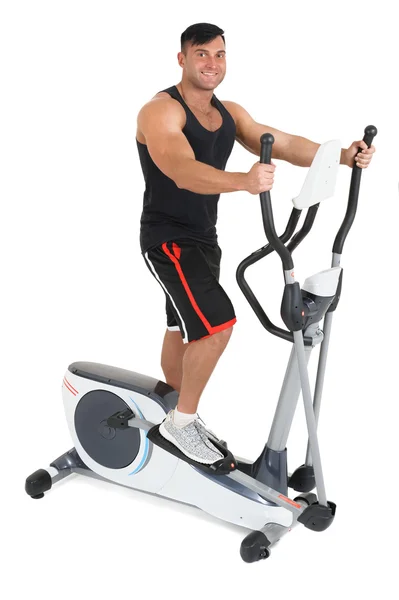 Young man doing exercises on elliptical cross trainer — Stock Photo, Image