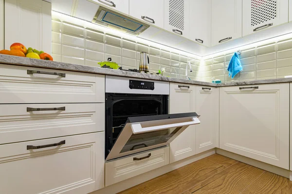 Белая кухня в классическом стиле, дверь духовки открыта — стоковое фото