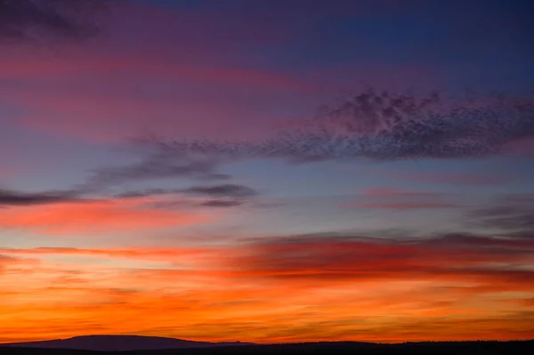 Bardzo kolorowy czerwony, niebieski, pomarańczowy i fioletowy późny zachód słońca — Zdjęcie stockowe