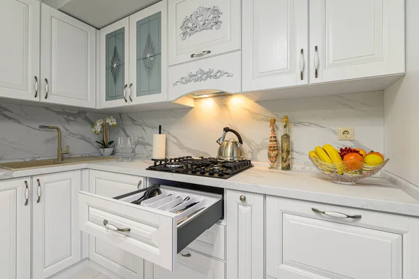 Відкриті ящики з посудом на сучасній білій кухні — стокове фото