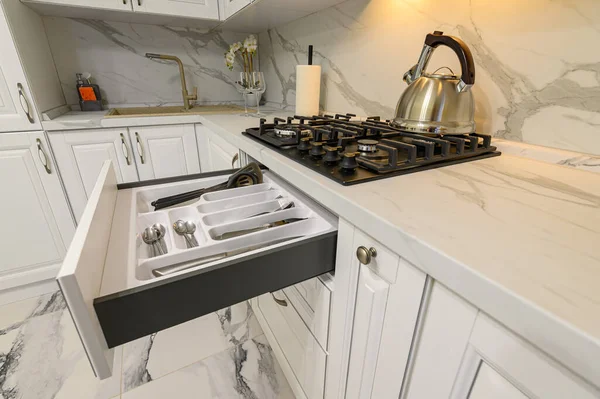 Cajones abiertos con utensilios de cocina en la moderna cocina blanca — Foto de Stock