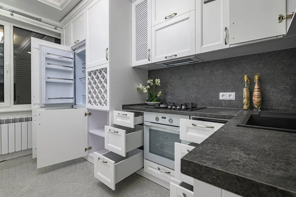 Otwarte drzwi i szuflady w nowoczesnej białej kuchni — Zdjęcie stockowe
