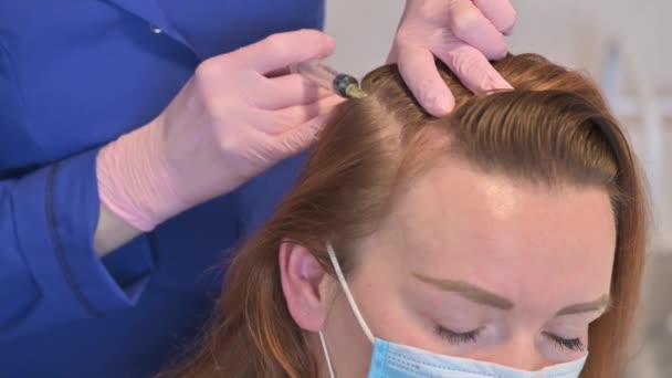 Косметолог робить ін'єкції вітамінів і мінералів у жіночій шкірі голови, щоб запобігти або уповільнити випадання волосся — стокове відео