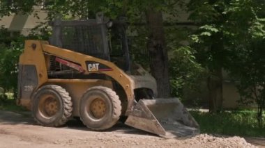 Dümen yükleyicisi inşaat alanında kum toprağı taşıyor.