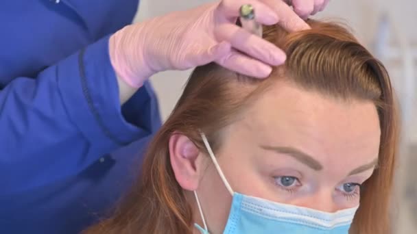 Un esteticista hace inyecciones de vitaminas y minerales en el cuero cabelludo de las mujeres, para prevenir o ralentizar la pérdida de cabello — Vídeo de stock