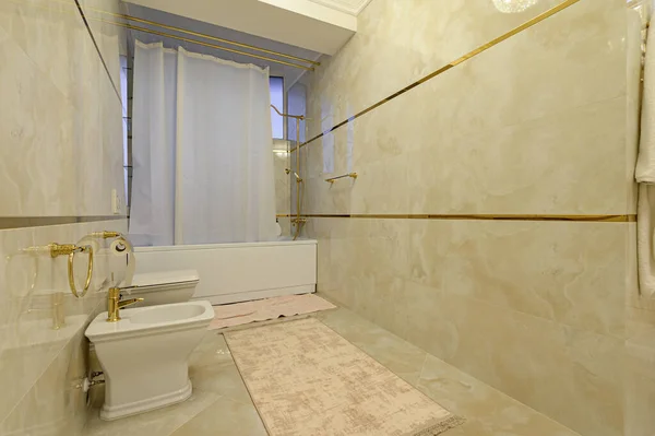 Современная роскошная бежевая и золотая ванная комната с туалетом — стоковое фото