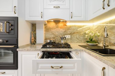 Modern beyaz mutfak içi ahşap mobilyalarla dolu.