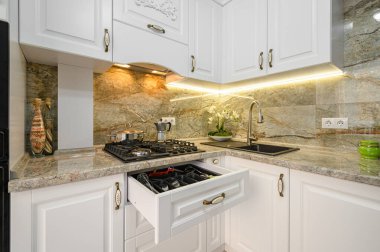 Modern beyaz mutfak içi ahşap mobilyalarla dolu.