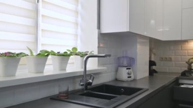 Modern beyaz ve gri mutfak iç mekanı, raflara odaklı.