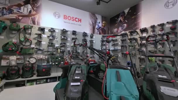 Panorama de estantes en una tienda de bricolaje con variedad de herramientas eléctricas, en su mayoría de la marca Bosch — Vídeo de stock