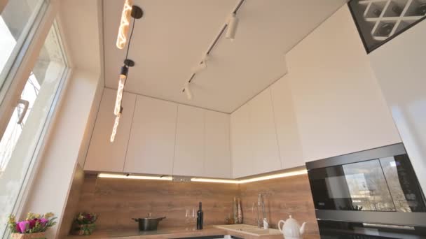 Wide angle tilt shot of modern white and wooden beige kitchen interior — Stock Video