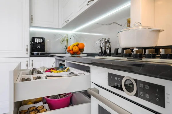 Розкішний білий сучасний кухонний інтер'єр, висунуті ящики, двері посудомийної машини відкриті — стокове фото